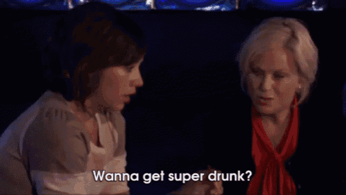 two women are sitting at a table and one of them is saying " wanna get super drunk ? "