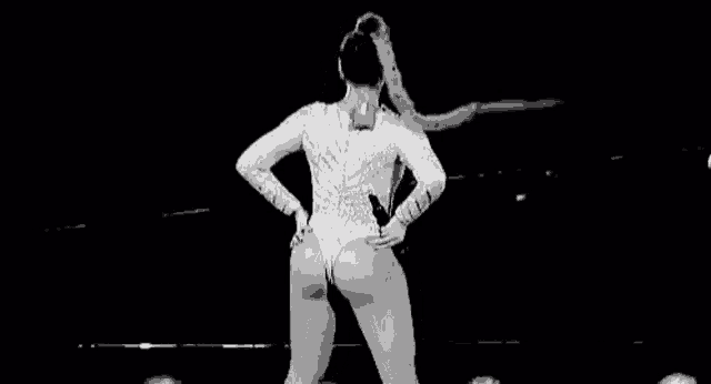 a black and white photo of a woman dancing on stage .