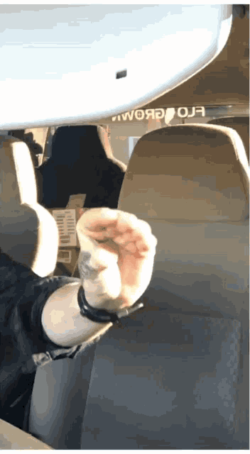 a person is sitting in a car with a rear view mirror that says " woяo oja "