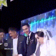 a bride and groom are standing next to each other at a wedding reception .