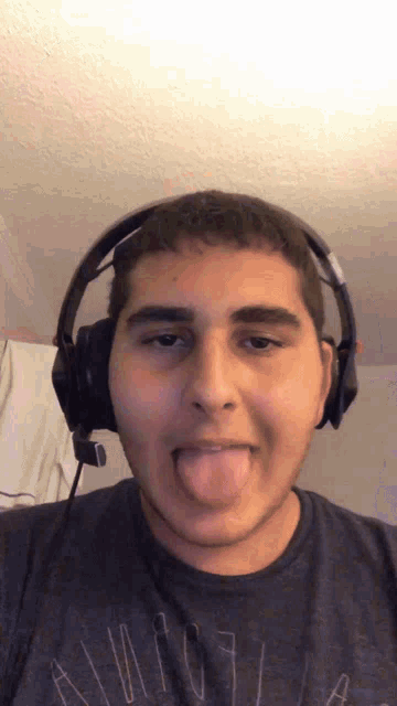 a man wearing headphones and a shirt that says aeropostale sticking out his tongue