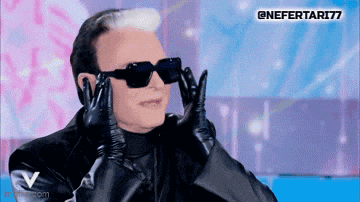 a man wearing sunglasses and gloves is making a funny face