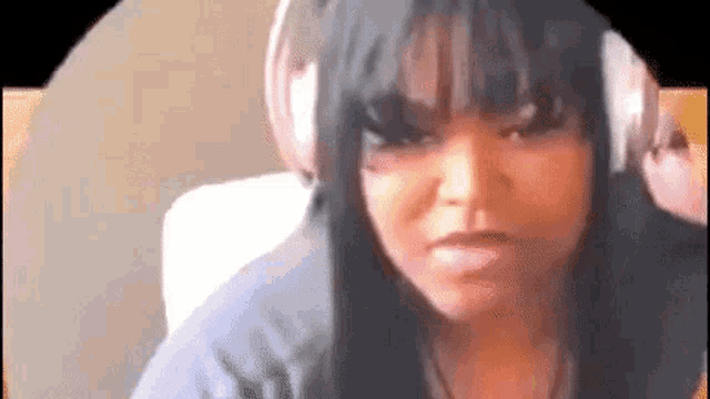 a woman is wearing headphones and making a funny face .