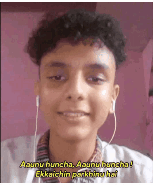 a young man is wearing ear buds and says aaunu huncha