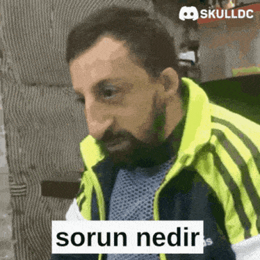 a man with a beard is wearing a yellow and black jacket with the word sorun on it