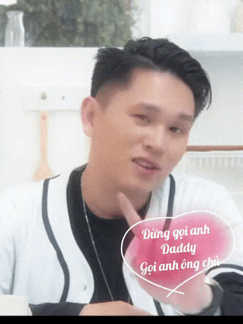 a man in a white and black jacket with a pink heart that says daddy on it