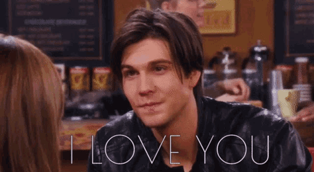 a man in a leather jacket says " i love you " to a woman