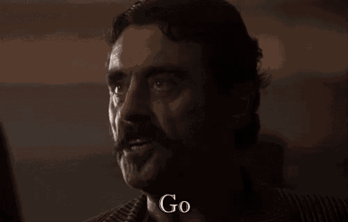 a man with a mustache is talking to someone in a dark room and says `` yourself '' .
