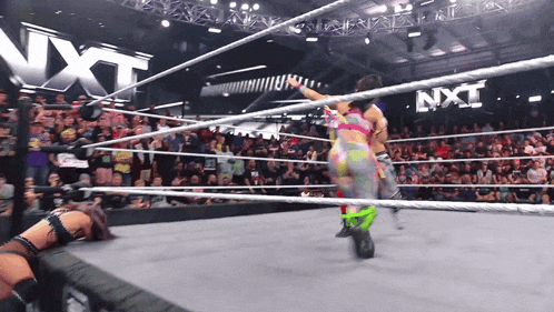 two women are wrestling in a ring with a nxt sign in the background