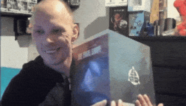 a bald man is smiling while holding a book that says " the final chapter "