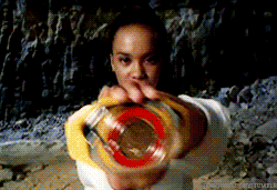 a woman in a white shirt is holding a yellow and red object in her hands ..