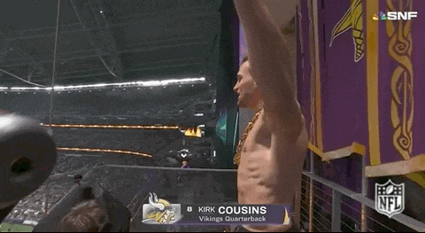 kirk cousins is wearing a gold chain while standing in the stands at a football game