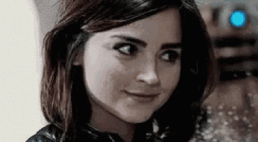 a close up of a woman 's face with a smile on her face and a robot in the background .