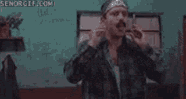 a man with a bandana on his head is saying waas sappening .