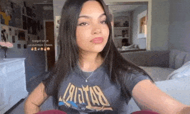 a girl is wearing a batgirl shirt and a spiderman shoes necklace