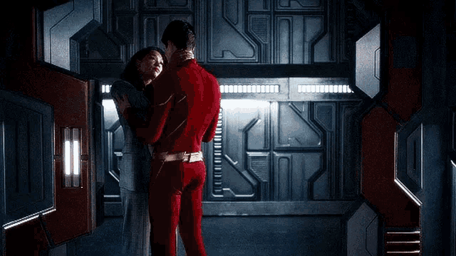 a man and a woman are hugging in a room .