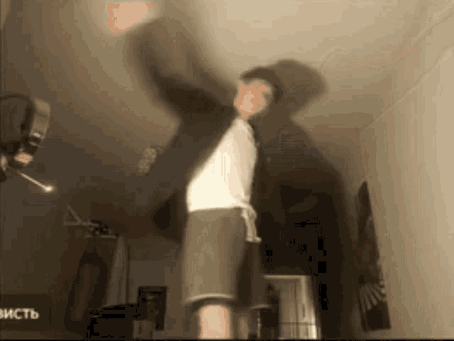 a man is dancing in a room with a sign that says висть