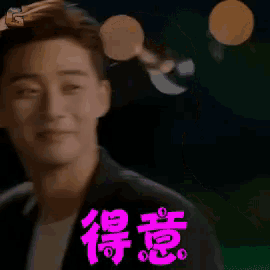 a man in a black suit is smiling with chinese writing on his face
