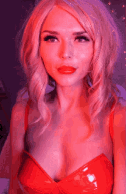 a woman with blonde hair and red lips is wearing a red dress