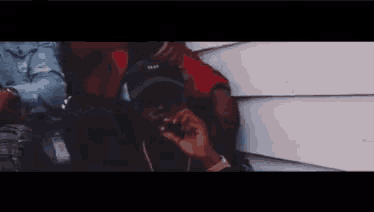 a man wearing a hat with the word trap on it smoking a cigarette