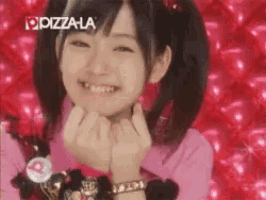 a girl with pigtails is smiling in front of a pizza la logo