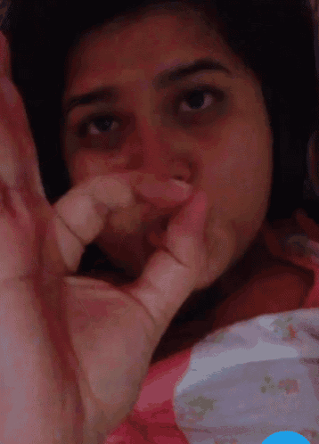 a woman is covering her face with her hand and making a stop sign