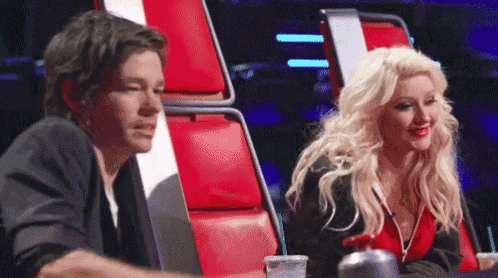 a man and a woman are sitting next to each other on a stage .