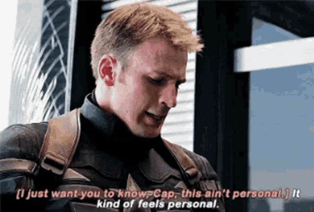 a man in a captain america uniform is talking to another man in a building .
