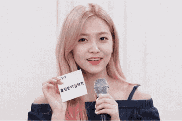 a girl with pink hair is smiling and covering her mouth with her hand