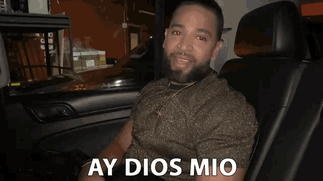 a man sitting in a car with ay dios mio written on the bottom