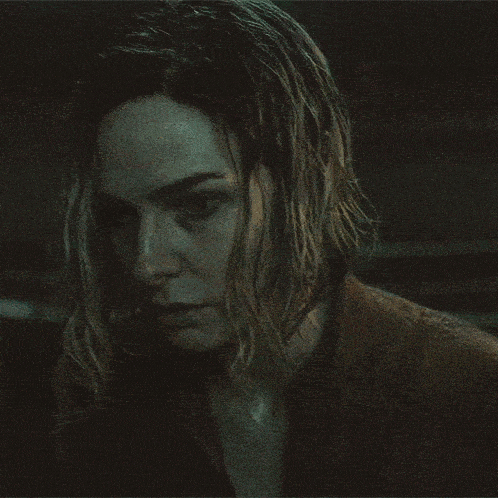 a close up of a woman 's face in a dark room