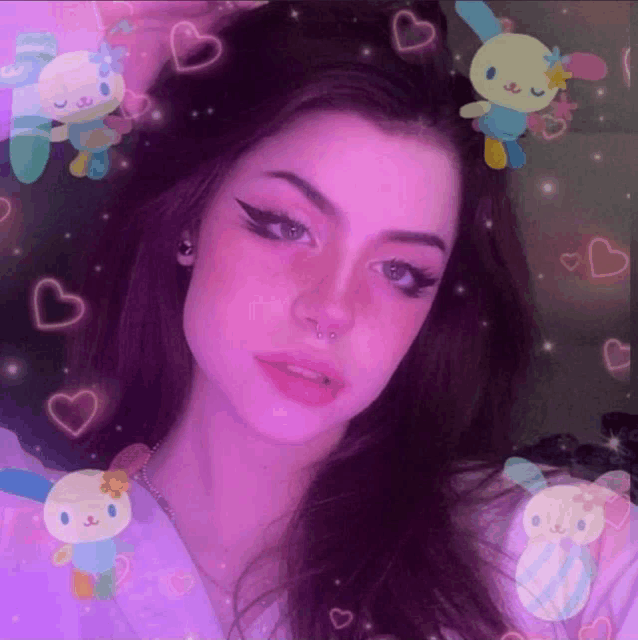 a girl with a nose ring is surrounded by stuffed animals and hearts .