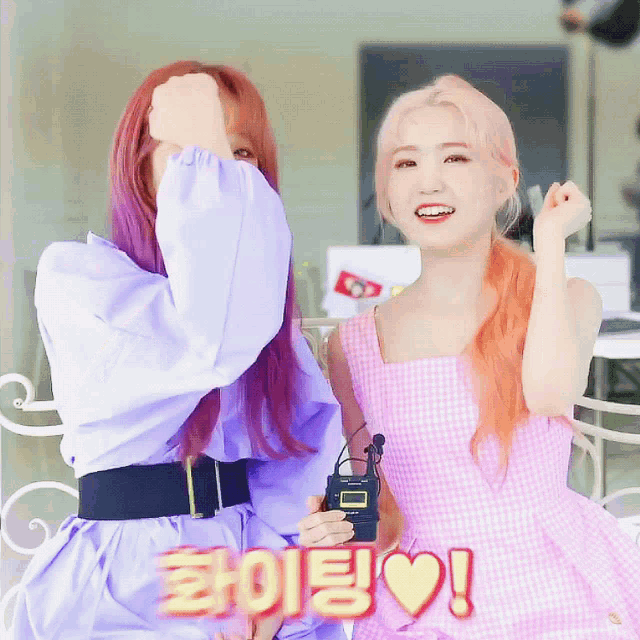 two girls are standing next to each other and one of them is wearing purple