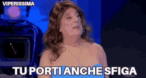a woman wearing a wig and a blue dress says tu porti anche spiga