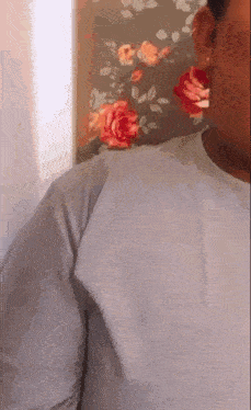 a close up of a person 's ear with a floral wallpaper in the background