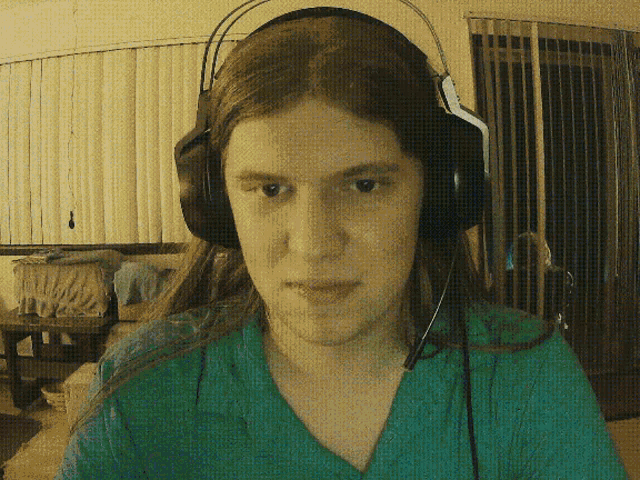 a woman wearing headphones looks at the camera