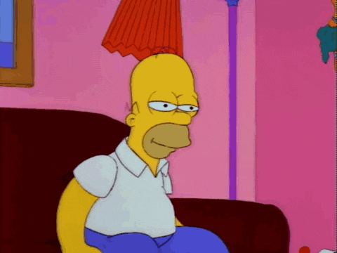 homer simpson is sitting on a couch in a pink room