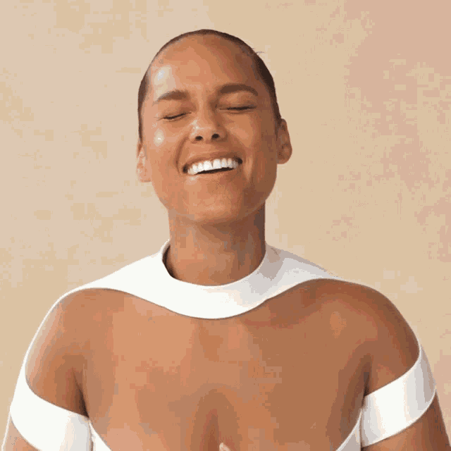 a woman with her eyes closed is smiling and wearing a white top