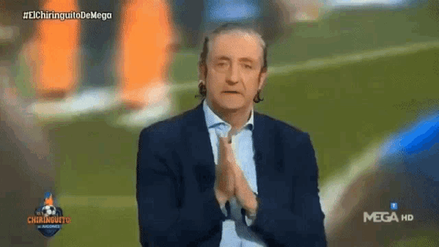 a man in a suit is clapping in front of a mega hd logo