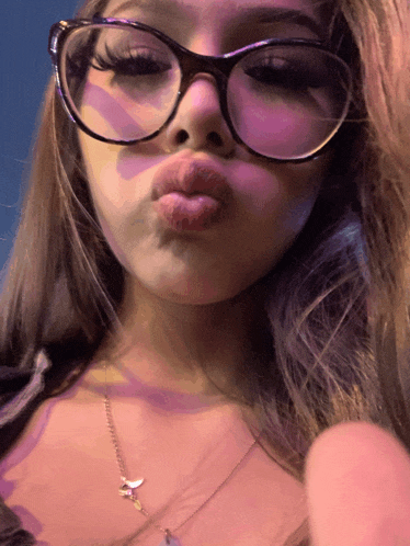 a girl wearing glasses and a necklace with a key