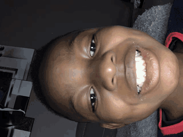 a close up of a child 's face with a smile on it