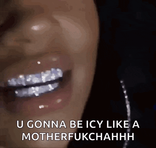 a close up of a woman 's mouth with diamonds on her teeth