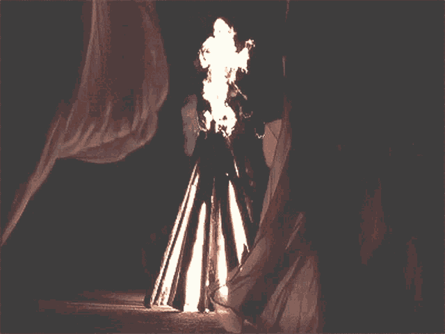 a close up of a person 's face with a flame coming out of it