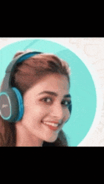 a woman wearing headphones is smiling and looking at the camera .