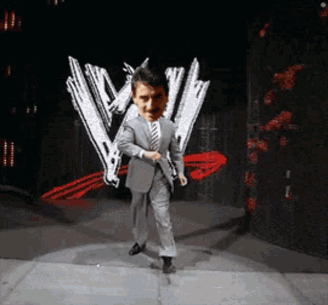 a man in a suit and tie is dancing on a stage in front of a w logo