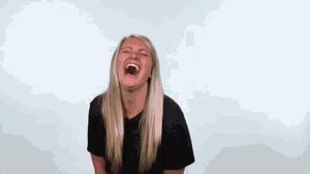 a woman is laughing with her mouth wide open