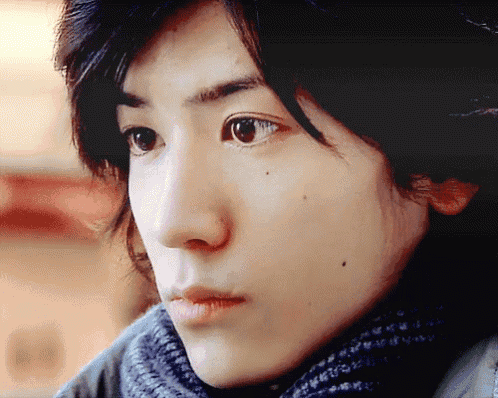 a closeup of a person 's face with a scarf around their neck