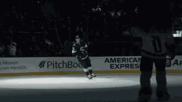 a hockey player stands on the ice in front of a sign that says pitchbook