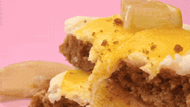 a close up of a cake with yellow frosting and a lemon slice on top