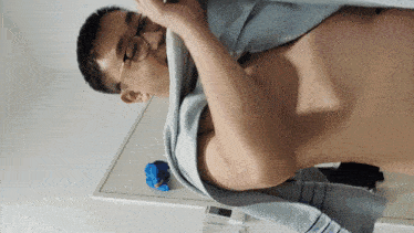 a man without a shirt is wrapped in a blue towel